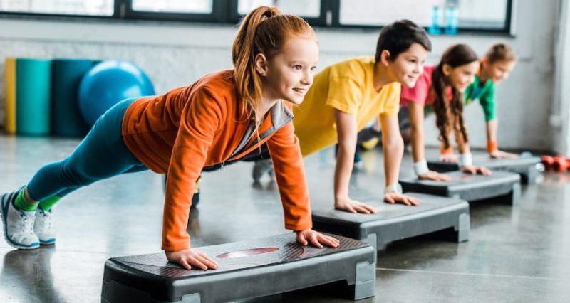 Children doing plank exercise with step platforms